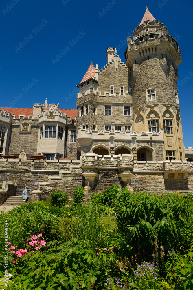 Garden flower bed and Gothic revival towers of Casa Loma castle in Toronto