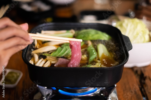 Shabu or suki yaki in the hot pot, sliced meat and vegetables boiled in soup. photo