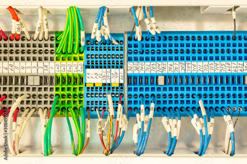 Close up of multicolored wiring connectors or terminal block for industrial electronic with marked cable wires. Number of lead-through terminals to connect the electrical cabinet. Block with wire.