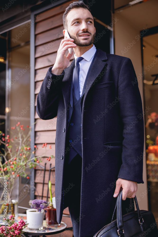 Positive delighted brunette man talking per telephone Positive delighted brunette man talking per telephone