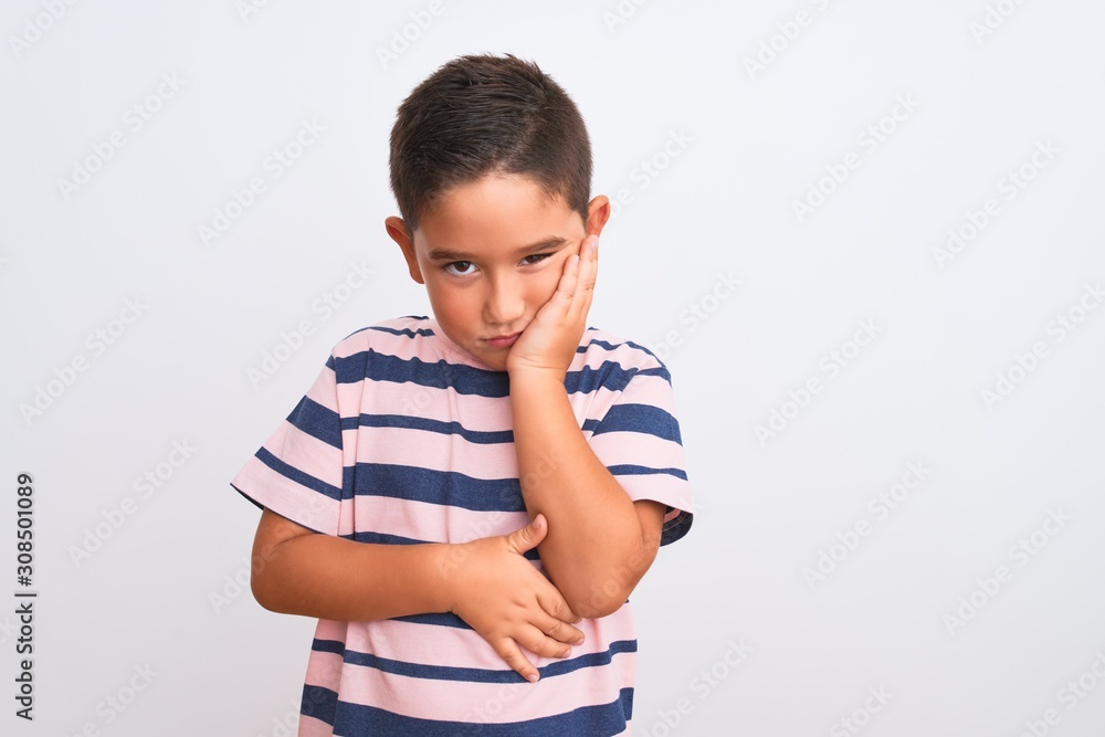 Beautiful kid boy wearing casual striped t-shirt standing over isolated white background thinking looking tired and bored with depression problems with crossed arms. Beautiful kid boy wearing casual striped t-shirt standing over isolated white background thinking looking tired and bored with depression problems with crossed arms.