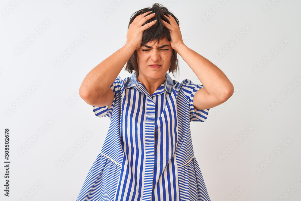 Young beautiful woman wearing blue striped shirt standing over isolated white background suffering from headache desperate and stressed because pain and migraine. Hands on head. Young beautiful woman wearing blue striped shirt standing over isolated white background suffering from headache desperate and stressed because pain and migraine. Hands on head.