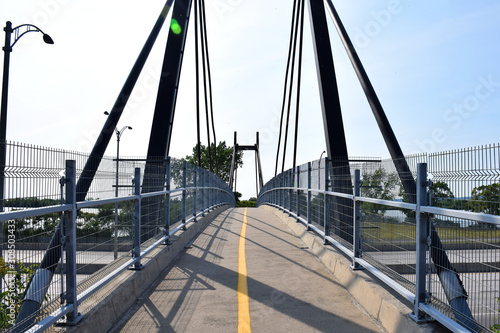 Bicycle and foot bridge over a highway with shadows, La Prairie, Quebec, Canada