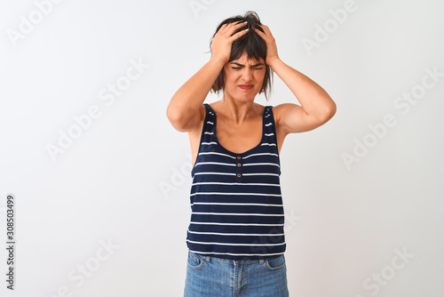 Young beautiful woman wearing striped t-shirt standing over isolated white background suffering from headache desperate and stressed because pain and migraine. Hands on head.