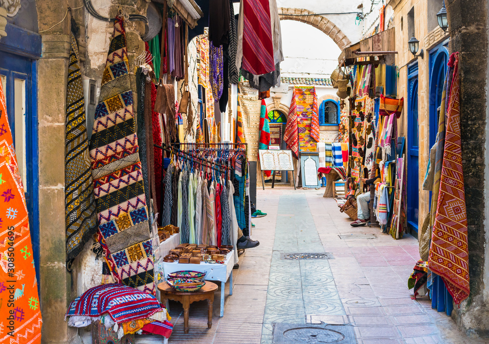 Moroccan carpets and clothing for sale on the narrow streets of Essaouira, Morocco