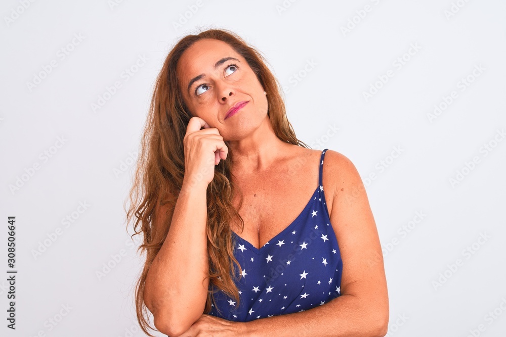 Middle age mature woman standing over white isolated background with hand on chin thinking about question, pensive expression. Smiling with thoughtful face. Doubt concept. Middle age mature woman standing over white isolated background with hand on chin thinking about question, pensive expression. Smiling with thoughtful face. Doubt concept.
