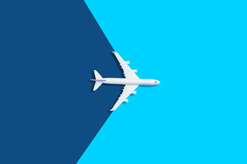 Flat lay design of travel concept with plane on blue background with copy space