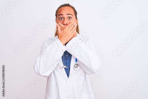 Middle age mature doctor woman wearing stethoscope over isolated background shocked covering mouth with hands for mistake. Secret concept.