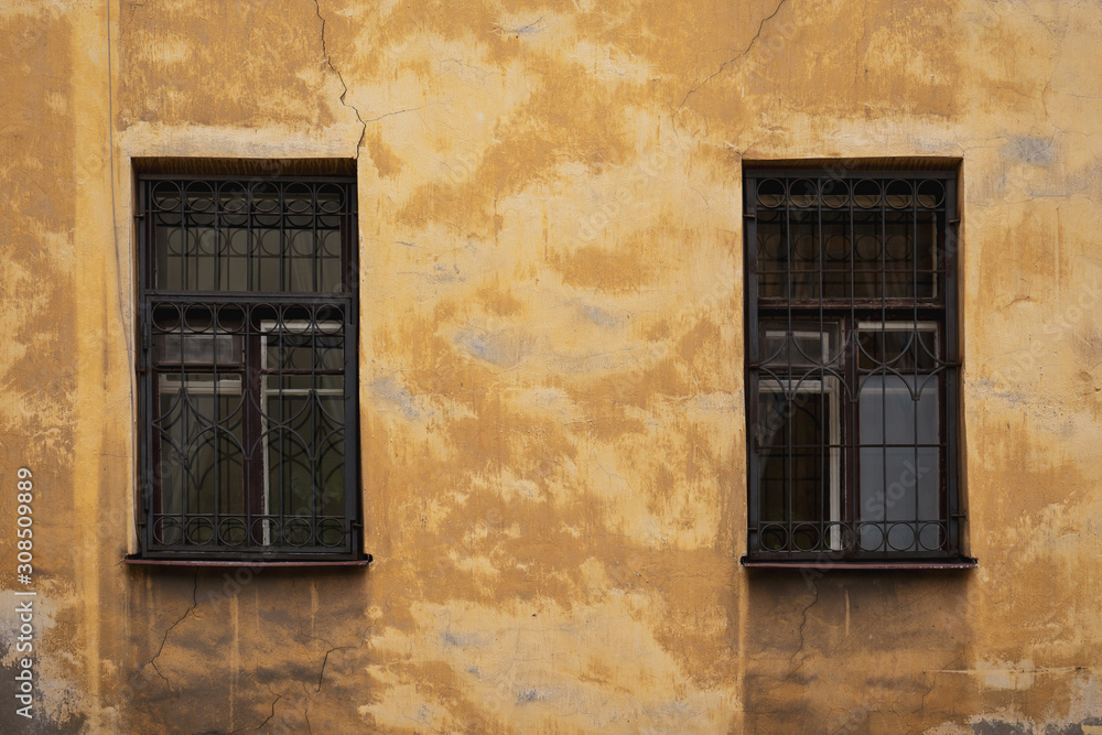 Two Windows on the yellow facade of the old house