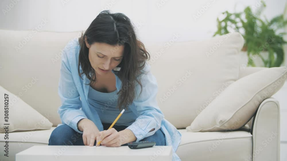 Business woman is talking on smartphone and sitting on the sofa at home. Slow motion. Copy space. 4K. Business woman is talking on smartphone and sitting on the sofa at home. Slow motion. Copy space. 4K.