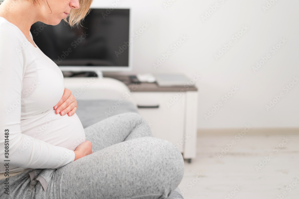Pregnant tired exhausted woman with stomach issues at home on a couch, being sick. Pregnant tired exhausted woman with stomach issues at home on a couch, being sick.