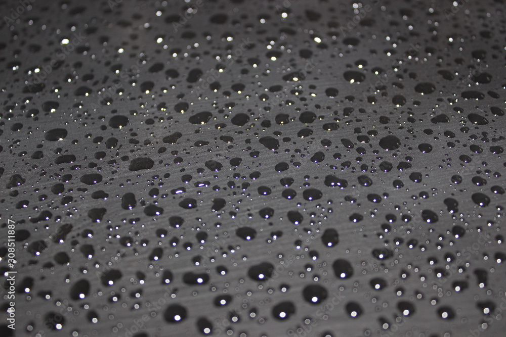 water droplet on a black surface water droplet on a black surface