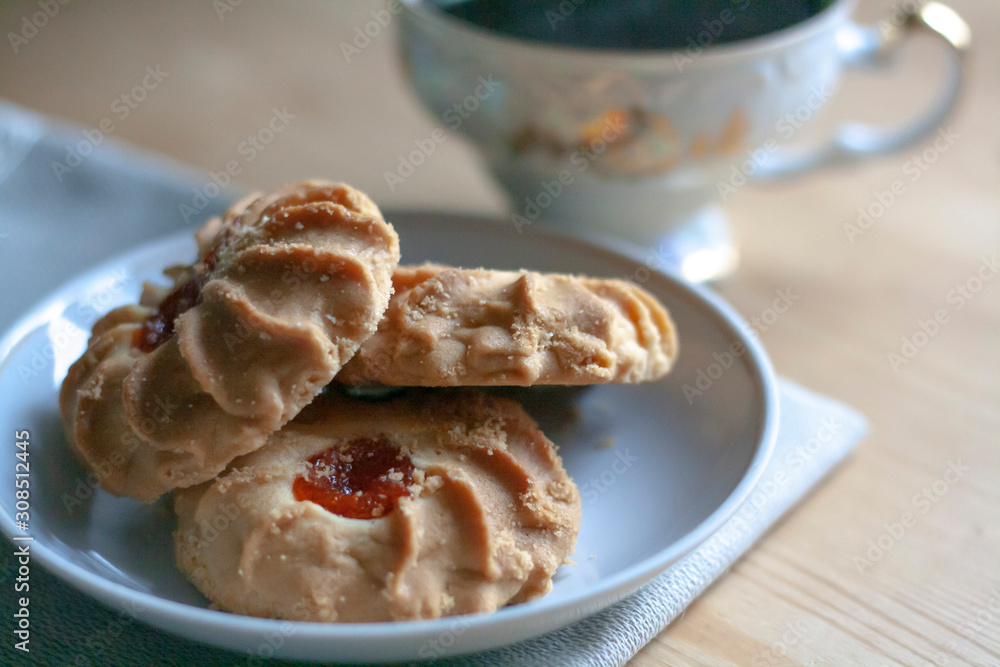 A cup of coffee and cookies in a saucer on a napkin on a wooden table A cup of coffee and cookies in a saucer on a napkin on a wooden table