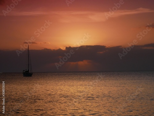 Hazy orange glow and calm sea of Cala Millor, Majorca before sunrise