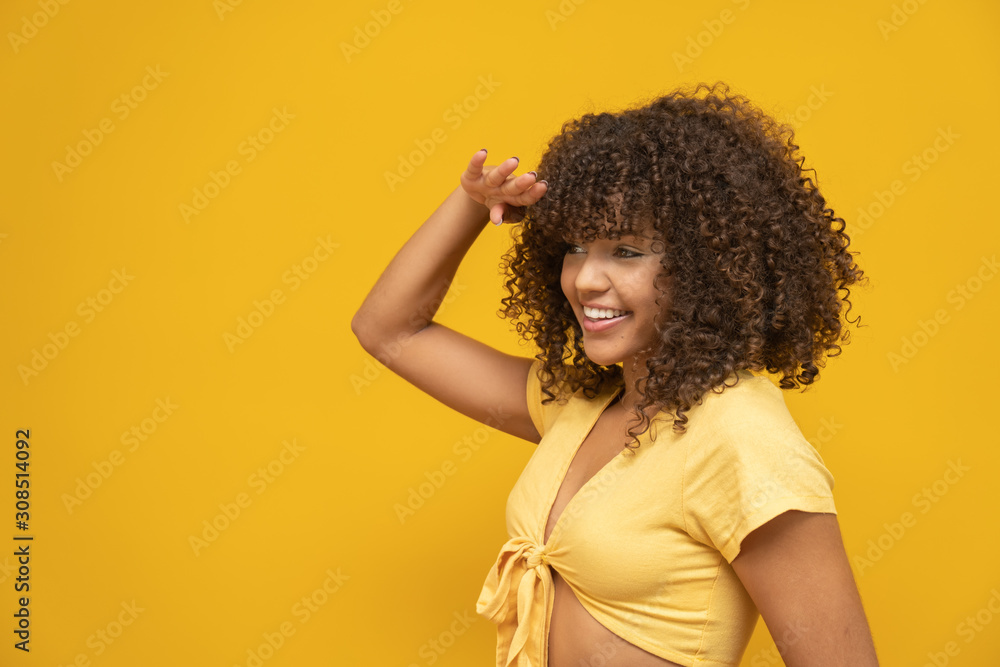 Beautiful brunette model smiling and seeing at side. Beautiful teeth. Curly hair. Brazilian young woman. Beautiful brunette model smiling and seeing at side. Beautiful teeth. Curly hair. Brazilian young woman.