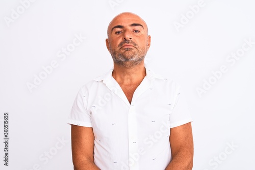 Middle age handsome man wearing elegant shirt standing over isolated white background with serious expression on face. Simple and natural looking at the camera.
