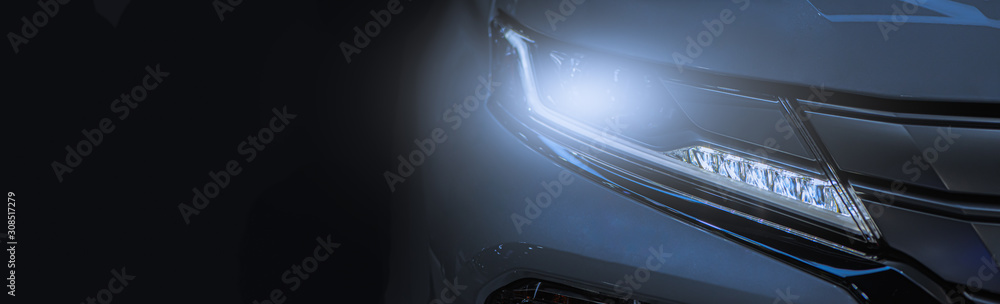 Modern sport car headlight with flare on the road. - obrazy, fototapety, plakaty 