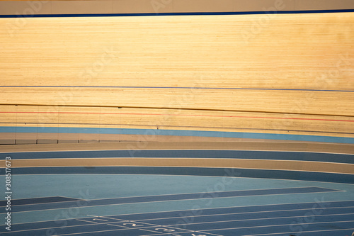 Tracks of an indoor track cycling velodrome with wooden course race-track and a blue floor photo