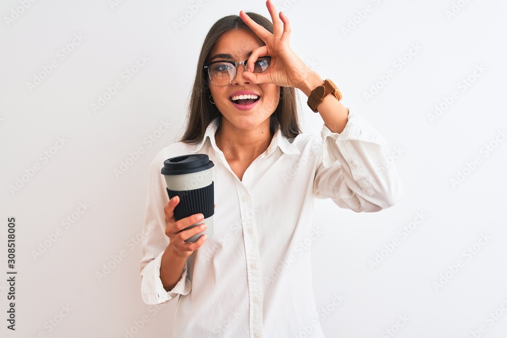 Young businesswoman wearing glasses drinking coffee over isolated white background with happy face smiling doing ok sign with hand on eye looking through fingers Young businesswoman wearing glasses drinking coffee over isolated white background with happy face smiling doing ok sign with hand on eye looking through fingers