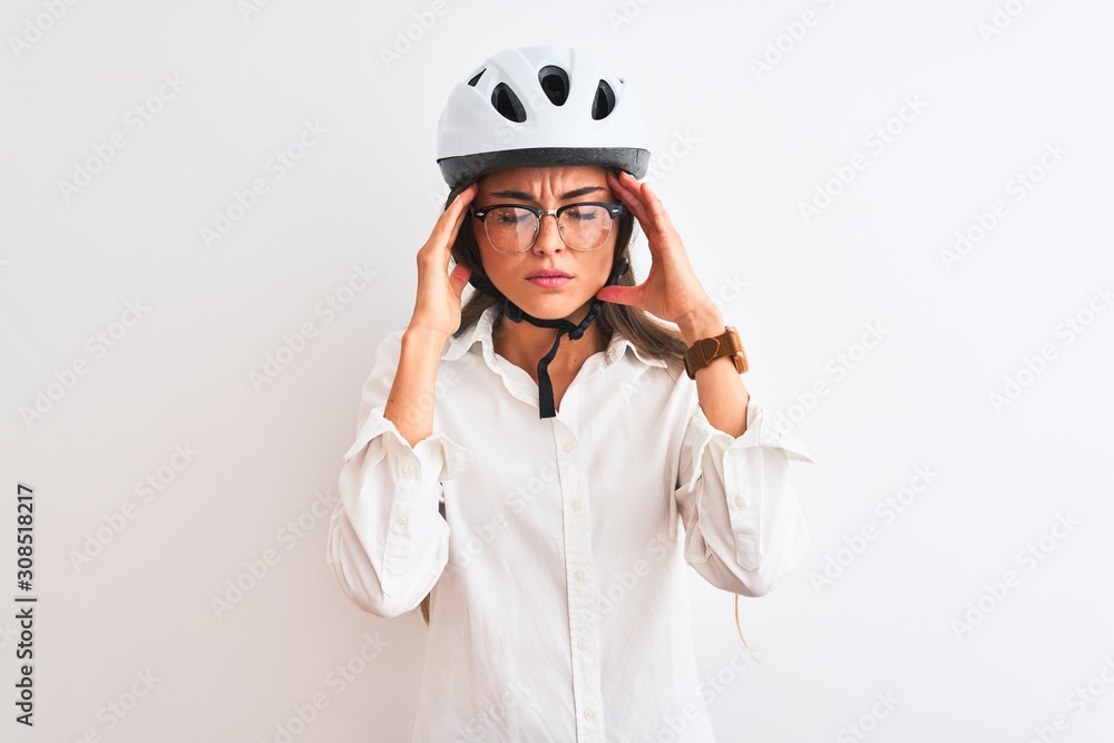 Beautiful businesswoman wearing glasses and bike helmet over isolated white background with hand on head for pain in head because stress. Suffering migraine. Beautiful businesswoman wearing glasses and bike helmet over isolated white background with hand on head for pain in head because stress. Suffering migraine.