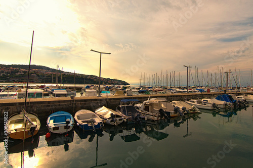 Picturesque landscape view of marine in Koper during sunset. Moored boats reflected on water. Famous touristic place and travel destination in Slovenia. Harbor of Koper, Slovenia © evgenij84