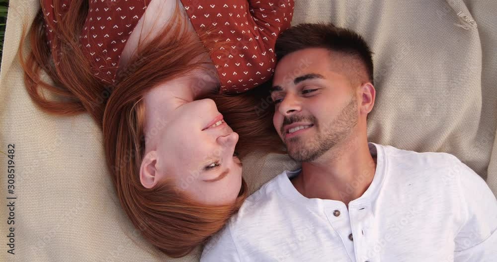 Happy young couple lying on picnic blanket, above view Happy young couple lying on picnic blanket, above view