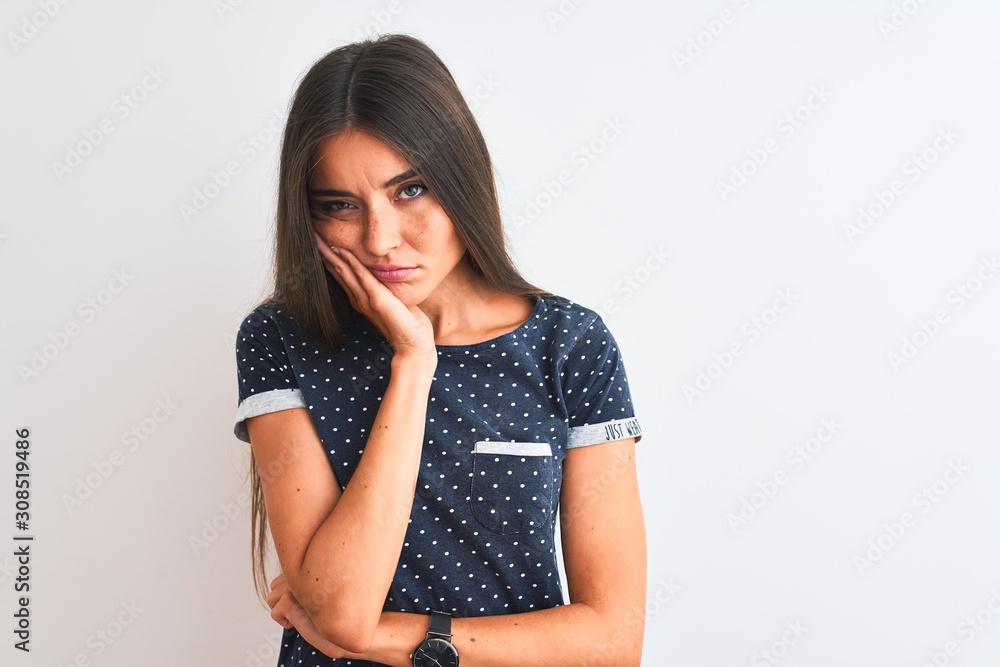 Young beautiful woman wearing blue casual t-shirt standing over isolated white background thinking looking tired and bored with depression problems with crossed arms. Young beautiful woman wearing blue casual t-shirt standing over isolated white background thinking looking tired and bored with depression problems with crossed arms.