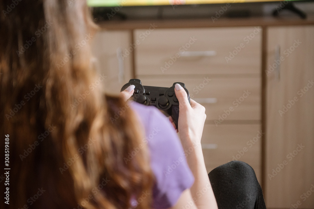 Happy woman playing video games, sitting on bed holding joystick. Happy woman playing video games, sitting on bed holding joystick.