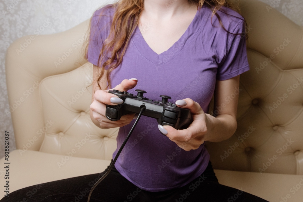 Happy woman playing video games, sitting on bed holding joystick. Happy woman playing video games, sitting on bed holding joystick.
