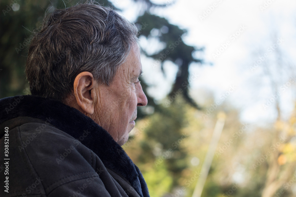 Portrait of a pensive senior man sitting on the bench, in the public park, outdoors. Old man relaxing outdoors and looking away. Portrait of elderly man enjoying retirement Portrait of a pensive senior man sitting on the bench, in the public park, outdoors. Old man relaxing outdoors and looking away. Portrait of elderly man enjoying retirement