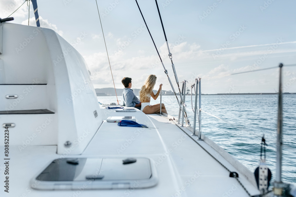 Young couple enjoying a summer day on a sailboat Young couple enjoying a summer day on a sailboat