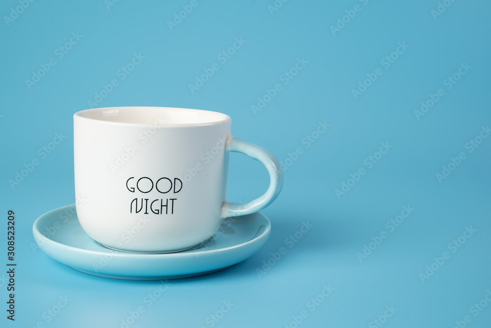 A white Cup on a saucer with an inscription on a blue background. Conveys freshness, vivacity of spirit. A white Cup on a saucer with an inscription on a blue background. Conveys freshness, vivacity of spirit.