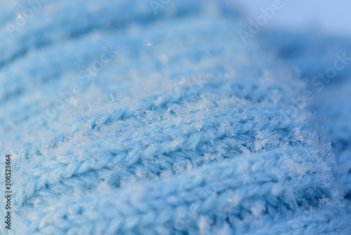 snowflakes on wool knitted hat blue. close up