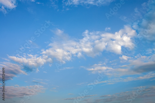 Blue summer sky with bright white cumulus clouds.
