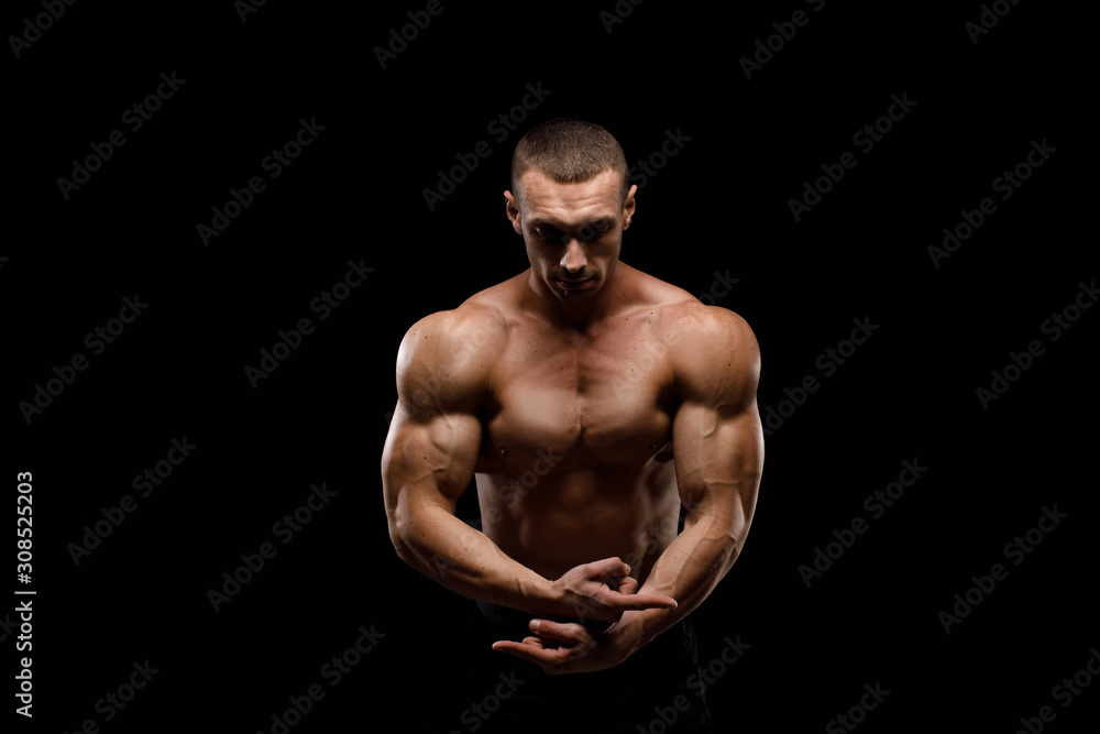 Sexy torso. Muscular model sports young man in jeans showing his press on a black background. Fashion portrait of sporty healthy strong muscle guy. Sexy torso. Muscular model sports young man in jeans showing his press on a black background. Fashion portrait of sporty healthy strong muscle guy.