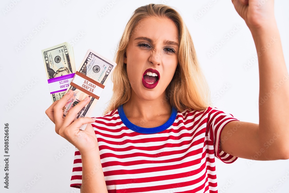 Beautiful woman wearing red striped t-shirt holding dollars over isolated white background annoyed and frustrated shouting with anger, crazy and yelling with raised hand, anger concept Beautiful woman wearing red striped t-shirt holding dollars over isolated white background annoyed and frustrated shouting with anger, crazy and yelling with raised hand, anger concept