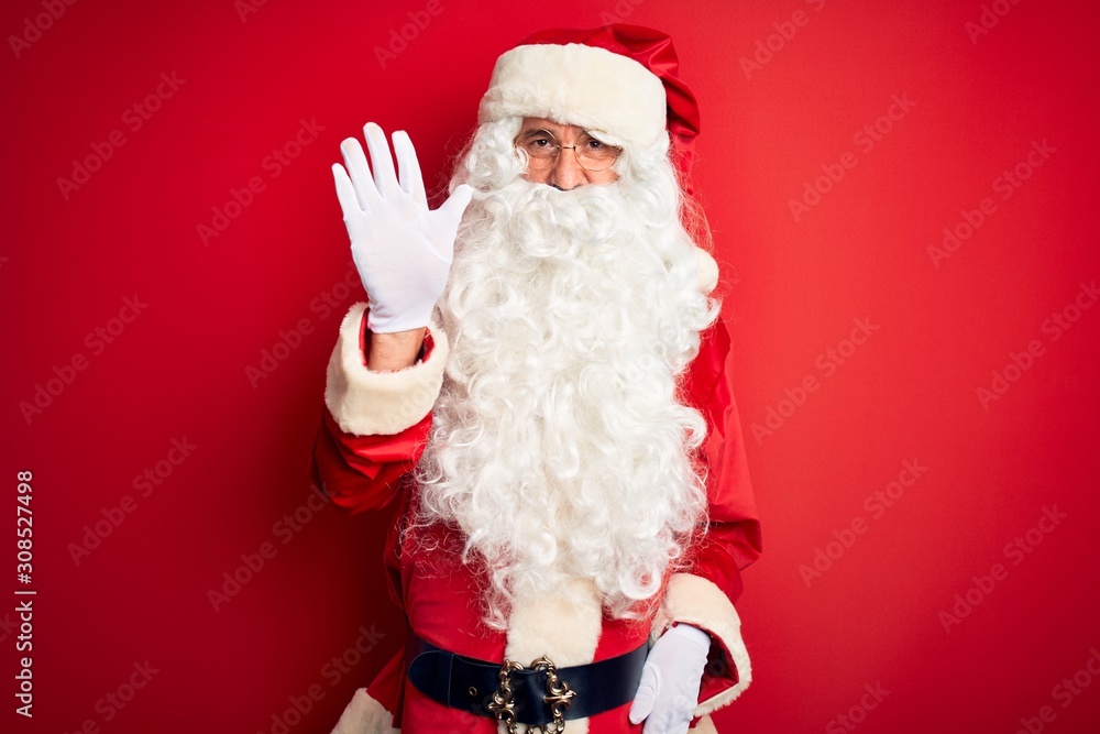Middle age handsome man wearing Santa costume standing over isolated red background showing and pointing up with fingers number five while smiling confident and happy.