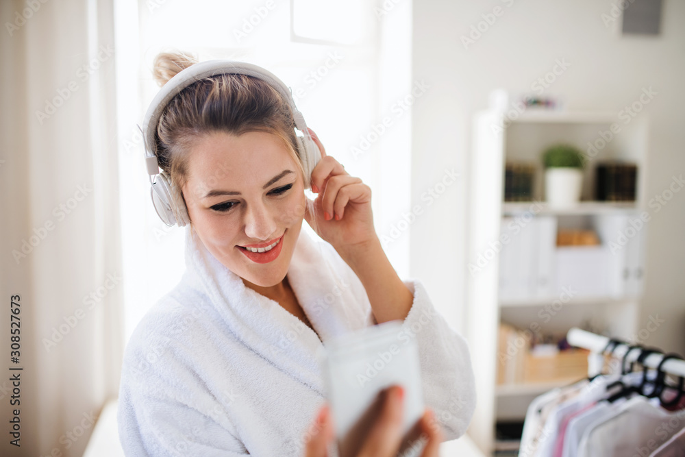 Young woman with headphones indoors at home in the morning. Young woman with headphones indoors at home in the morning.