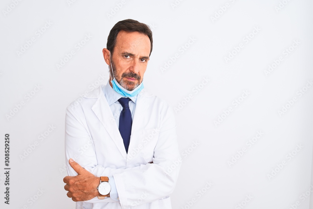 Middle age scientist man wearing coat and medical mask over isolated white background skeptic and nervous, disapproving expression on face with crossed arms. Negative person.