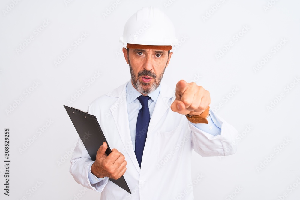 Senior engineer man wearing security helmet holding clipboard over isolated white background pointing with finger to the camera and to you, hand sign, positive and confident gesture from the front Senior engineer man wearing security helmet holding clipboard over isolated white background pointing with finger to the camera and to you, hand sign, positive and confident gesture from the front
