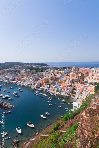 Panoramic view of beautiful Procida on a sunny summer day. Colorful cafes  houses and restaurants  fishing boats and yachts  clear blue sky and the azure sea on the island of Procida  Italy. Napoli