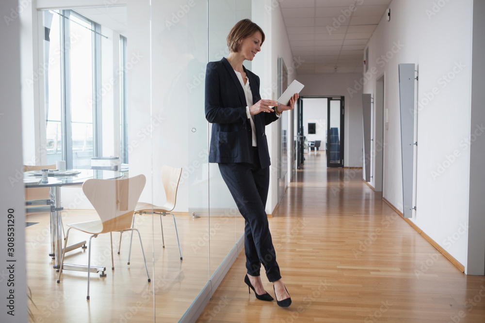 Businesswoman using digital tablet in office hall Businesswoman using digital tablet in office hall