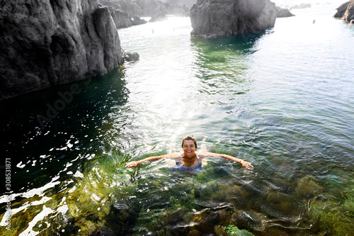 happy woman in holidays swimming in natural pools, Porto Moniz village , Madeira Island