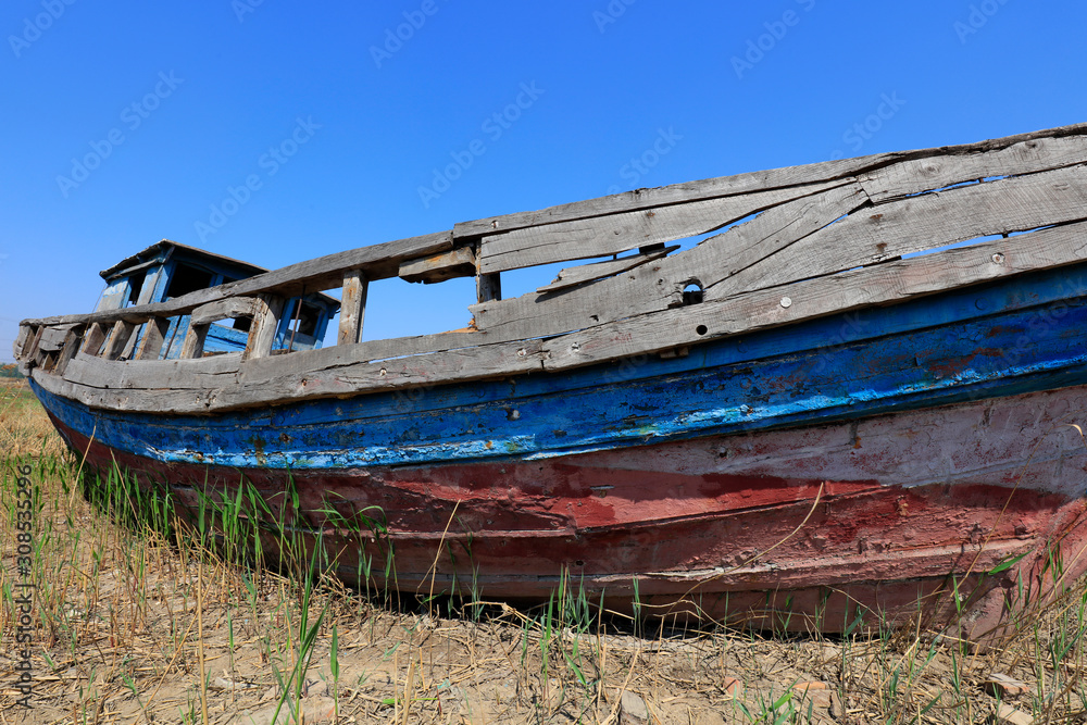 The broken wooden boat is on land The broken wooden boat is on land