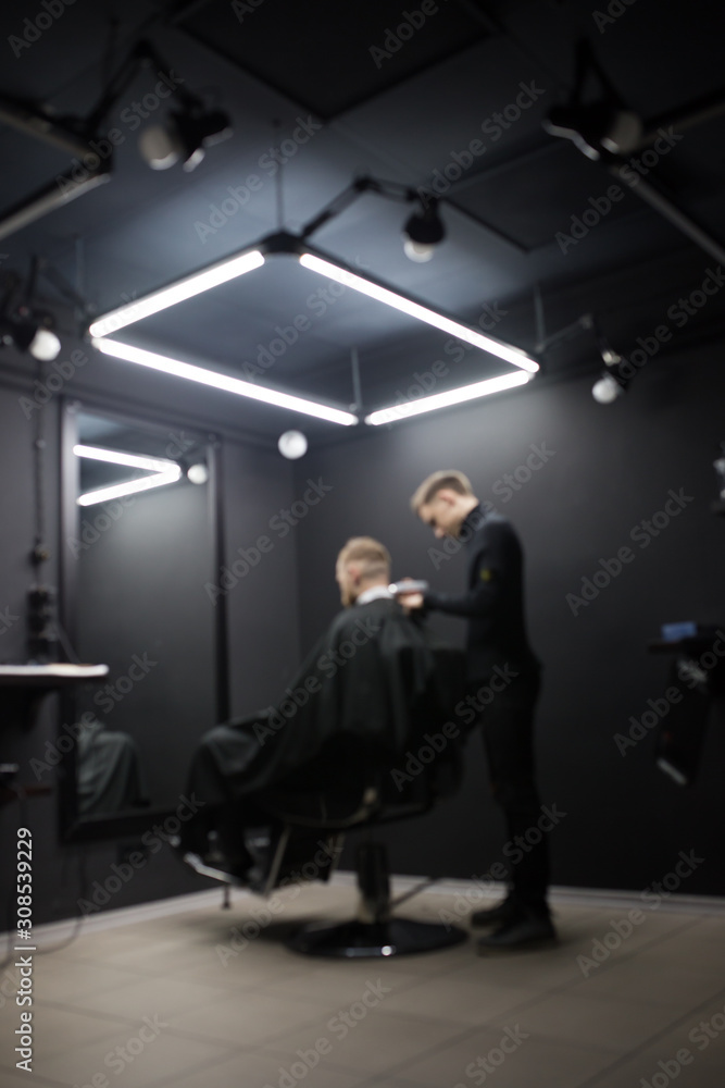 Blurred photo of a barber shop room in black style and lamps. Blurred photo of a barber shop room in black style and lamps.