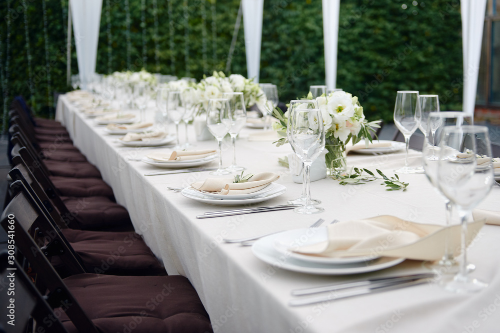 Table setting with sparkling wineglasses and cutlery in tent outdoors, copy space. Place setting at wedding reception. Table served for wedding banquet in restaurant