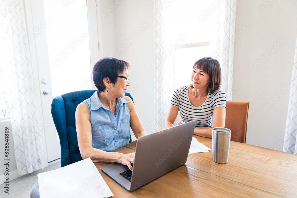 Family Business Owner Working With Daughter on Bills Family Business Owner Working With Daughter on Bills