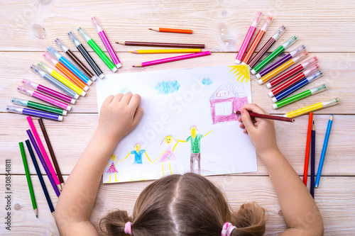 A child draws a birthday card with his family. Drawing made by a child with colorful felt-tip pens and pencils. Happy family. Child's drawing