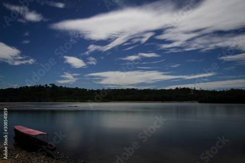 A boat on the Napo River illuminated by moonlight in a long exposure shot. Ecuador
