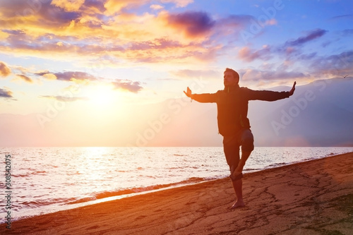 Person practicing yoga in balance position. Man make breathing exercise. Wellness and healthy lifestyle concept.